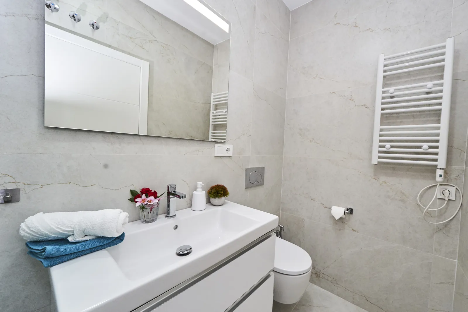 Baño moderno con mármol y toallero en Casa Florence