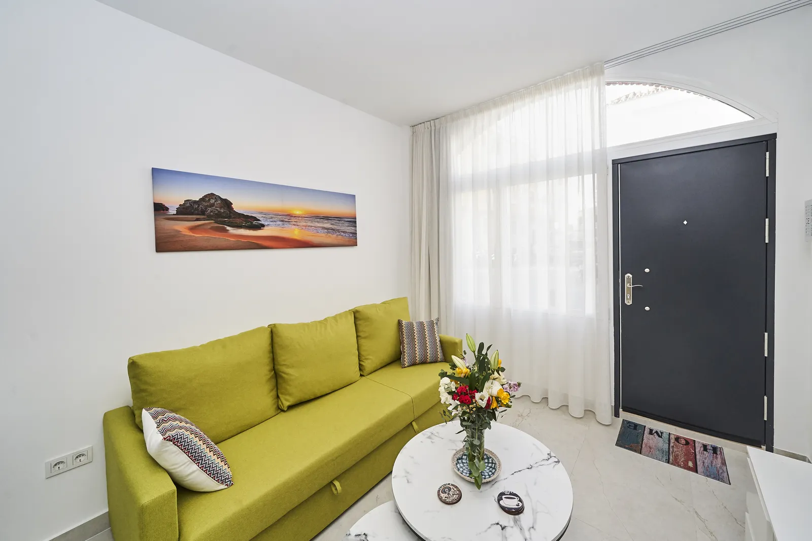 Salón con sofá, TV y entrada con arco en Casa Florence
