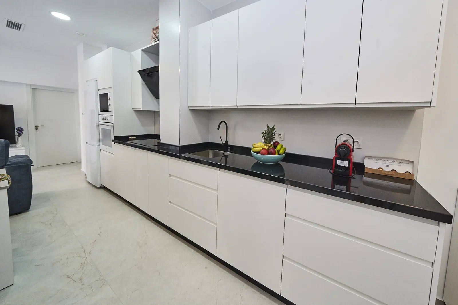 Cocina amplia con encimera de granito negro en Casa Isolde
